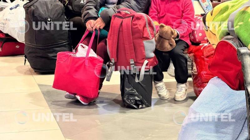 Familias con niños aguardan a la salida de buses. Familias con niños aguardan a la salida de buses.