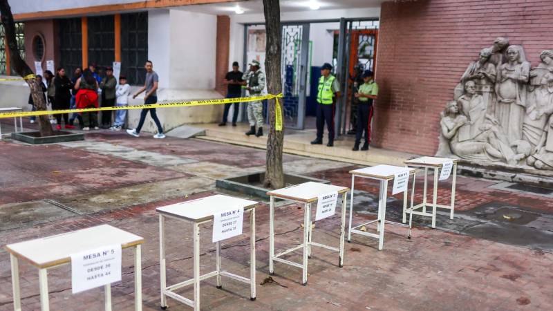 Personas esperan para ejercer su voto en un centro de votación este domingo, en Caracas (Venezuela). Personas esperan para ejercer su voto en un centro de votación este domingo, en Caracas (Venezuela).