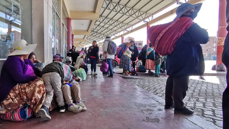 Las familias esperan en el piso la llegada de un minibús Las familias esperan en el piso la llegada de un minibús