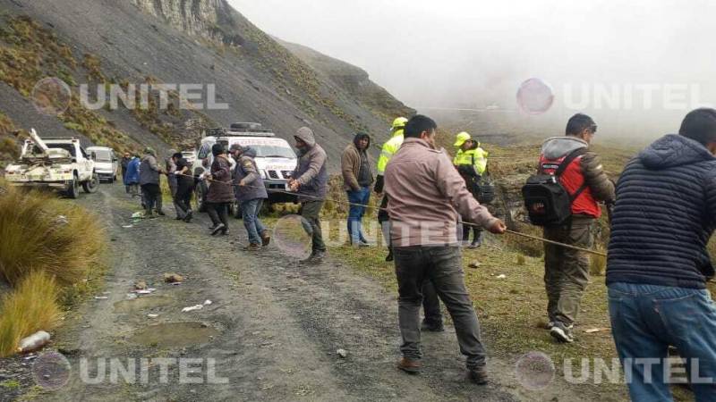 Personas colaboran durante el rescate del vehículo. 