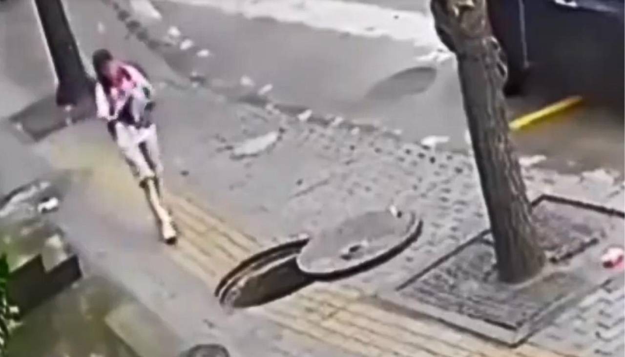 Mujer que caminaba distraída en una calle terminó en el fondo de una alcantarilla 