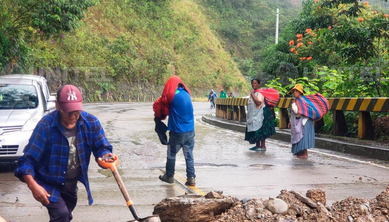 Turistas y viajeros caminan bajo la lluvia debido a bloqueos en el norte de La Paz 