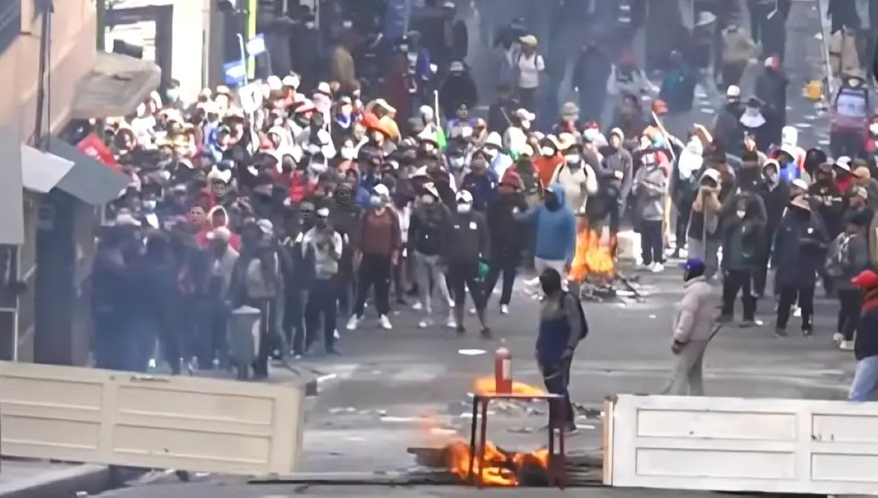 Manifestantes destruyen la puerta de un edificio para levantar barricada cerca de la plaza Murillo