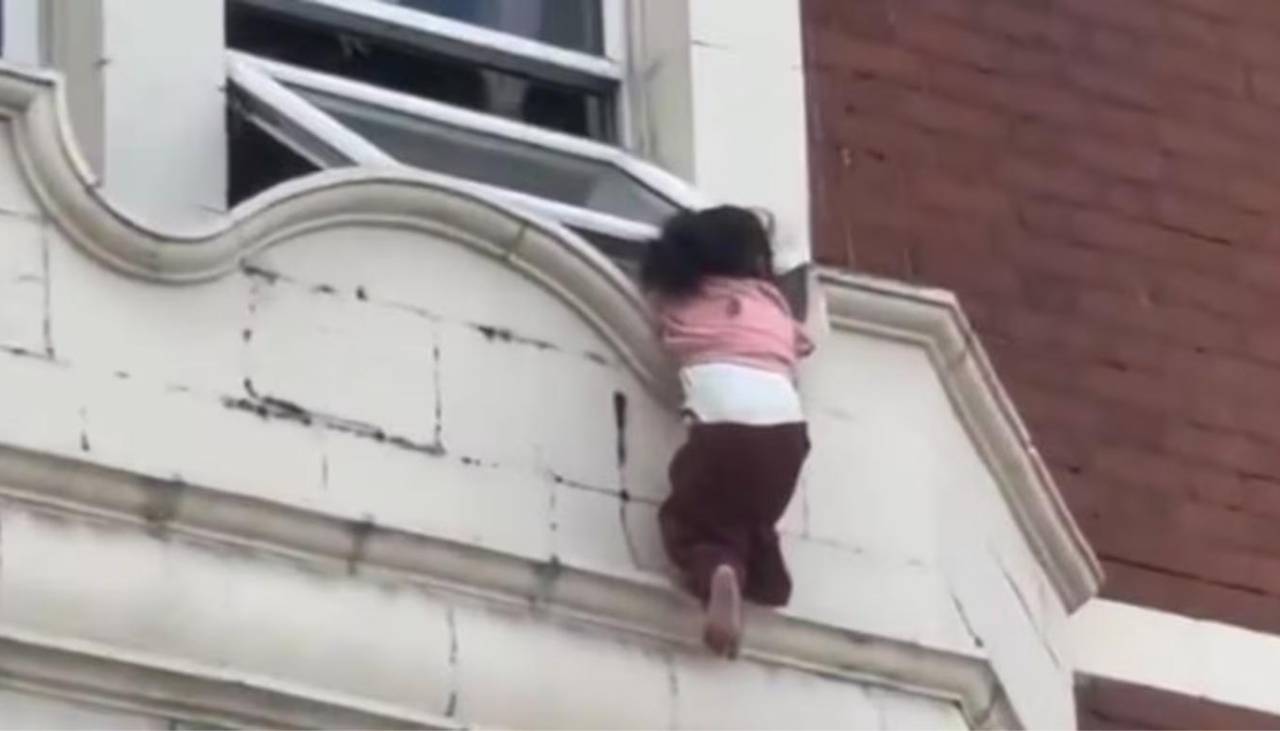 Milagroso rescate: niña es salvada tras quedar colgada en la ventana de un edificio