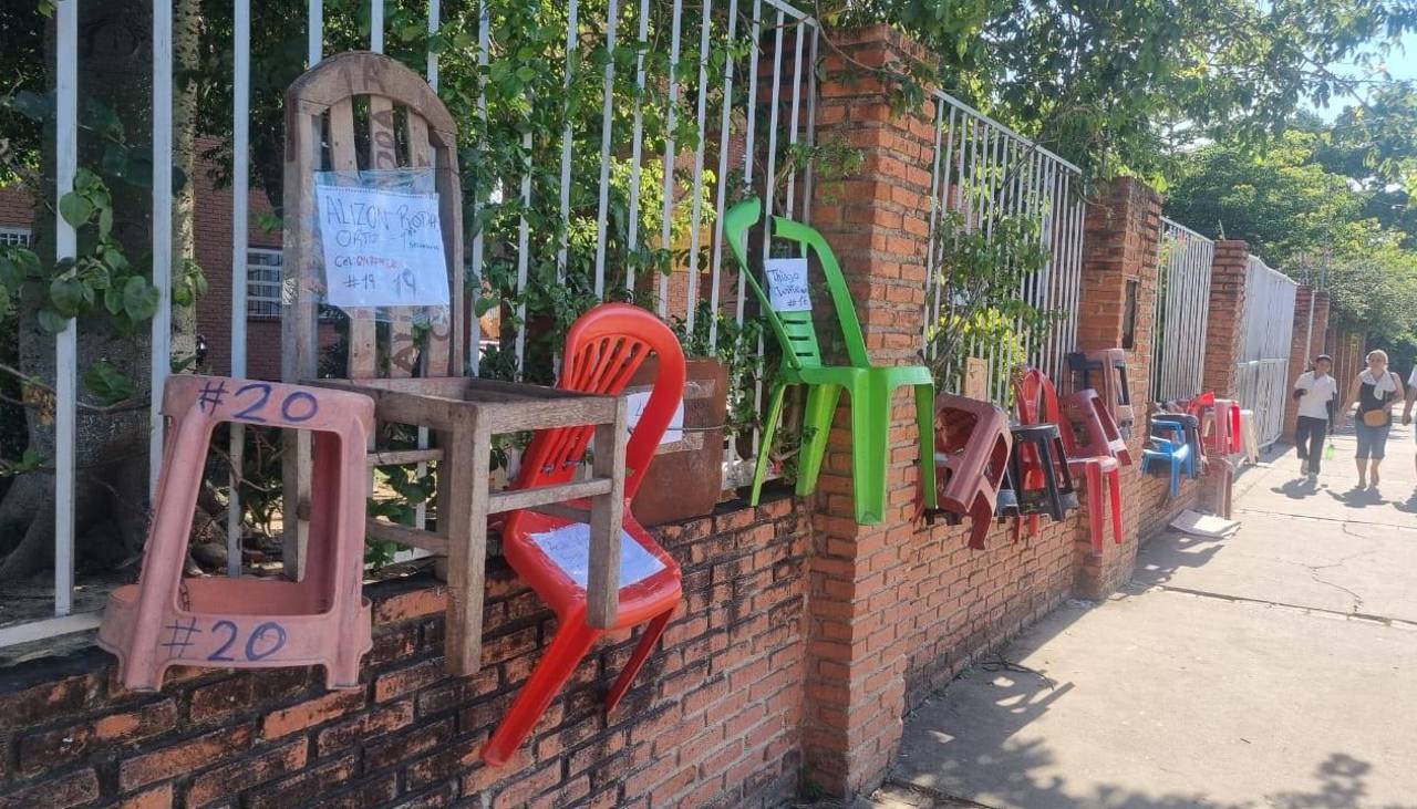 Padres amarran sillas en un colegio en busca de conseguir un espacio para la inscripción de sus hijos