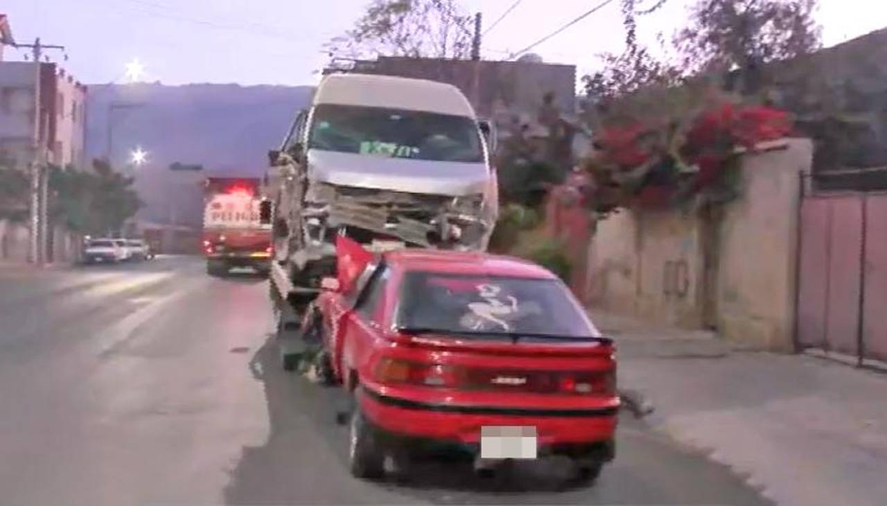 Choque frontal entre vehículos en una intersección afecta fachada de vivienda