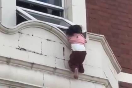 Milagroso rescate: niña es salvada tras quedar colgada en la ventana de un edificio