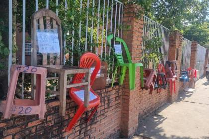 Padres amarran sillas en un colegio en busca de conseguir un espacio para la inscripción de sus hijos