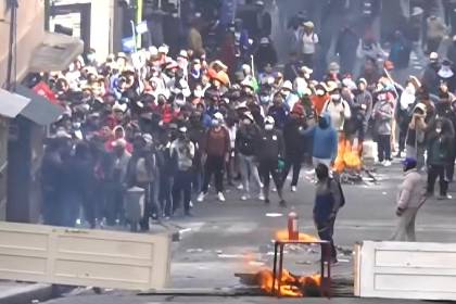 Manifestantes destruyen la puerta de un edificio para levantar barricada cerca de la plaza Murillo