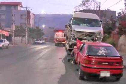 Choque frontal entre vehículos en una intersección afecta fachada de vivienda