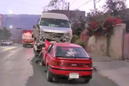 Choque frontal entre vehículos en una intersección afecta fachada de vivienda