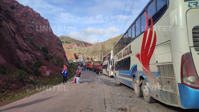 Viajeros caminan debido al deslizamiento en la carretera.