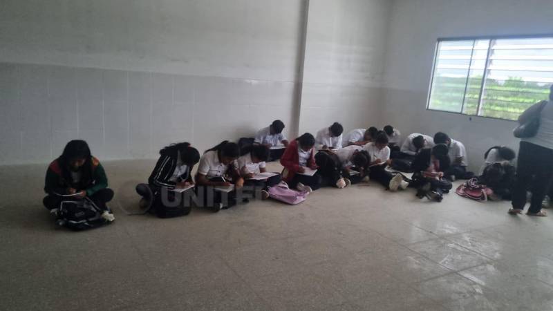 Los estudiantes toman apuntes apoyados en sus piernas