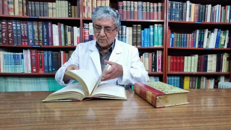 El médico Samuel Córdova muestra los libros que donó a la biblioteca 