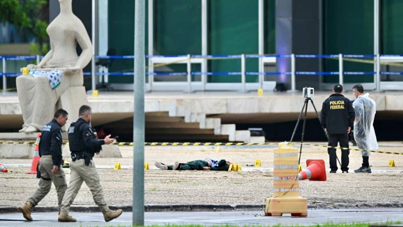 Forenses de la Policía Federal de Brasil junto al cuerpo de un hombre que portaba explosivos y que murió en una explosión cuando intentaba atacar la Corte Suprema de Brasil en Brasilia el 13 de noviembre