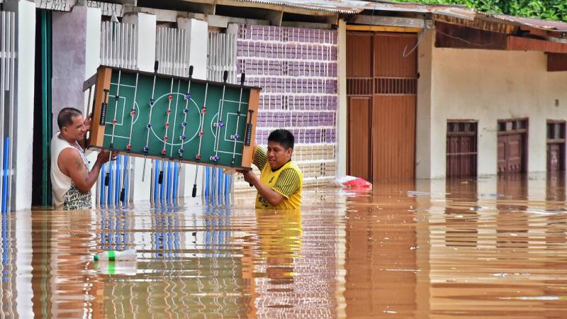 La gente rescata algunas de sus pertenencias de sus casas inundadas.
