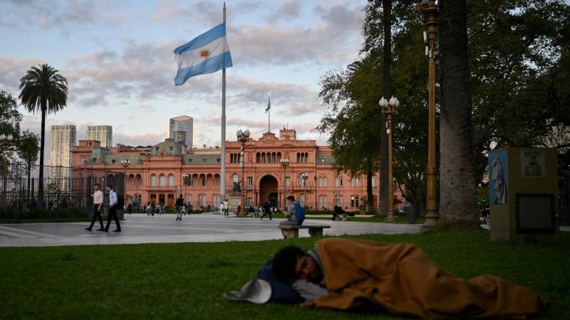 Un hombre sin hogar duerme en la plaza de Mayo frente al palacio presidencial Casa Rosada en Buenos Aires el 25 de septiembre de 2024