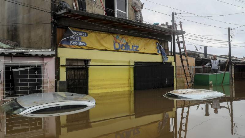 Moradores permancen sobre sus casas inundadas en el barrio Humaita.