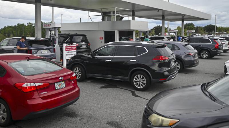 La gente hace fila en sus automóviles para comprar combustible.