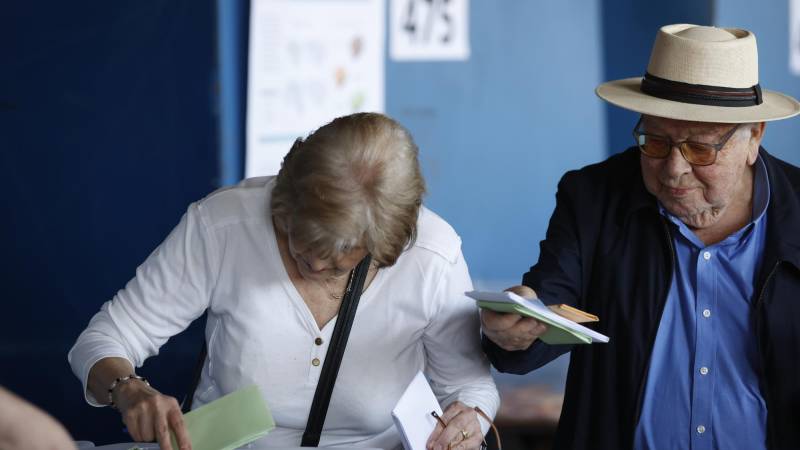 Personas votan en el centro de votación Estadio Nacional, en Santiago.