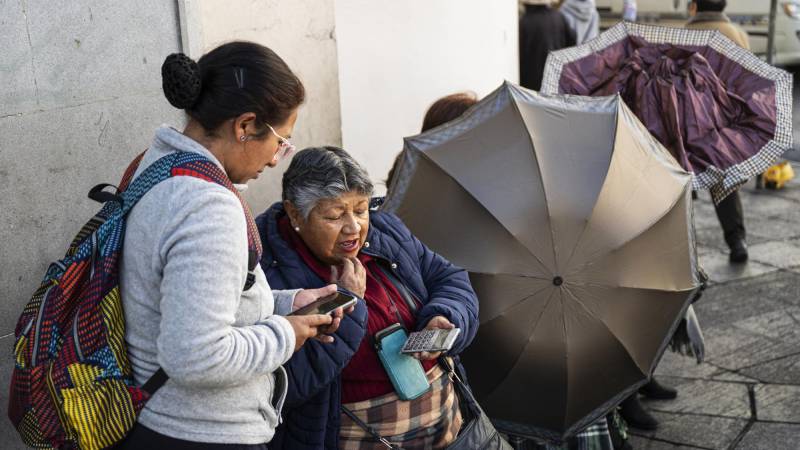 Una mujer calcula el cambio de dólares en una calle en La Paz