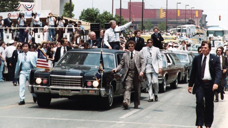 Jimmy Carter (C-R) con el senador John Glenn encima de su limusina durante una visita de campaña de reelección a Columbus.