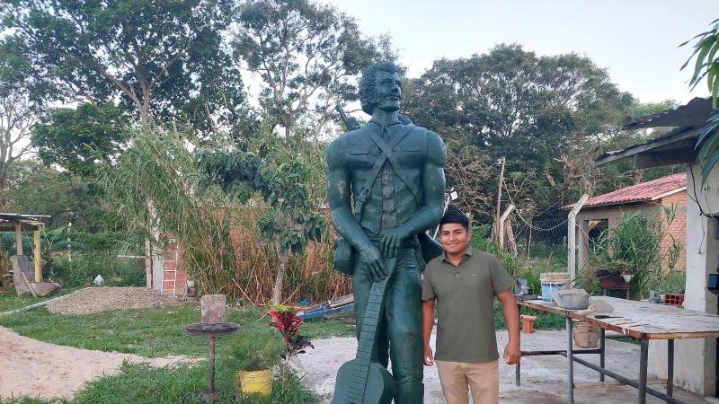 Escultor junto a su obra 