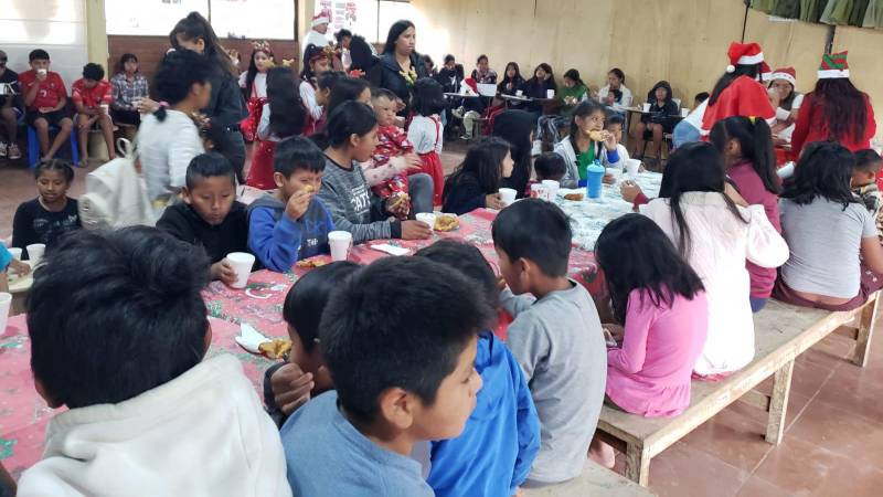 Niños disfrutando de chocolatada navideña.