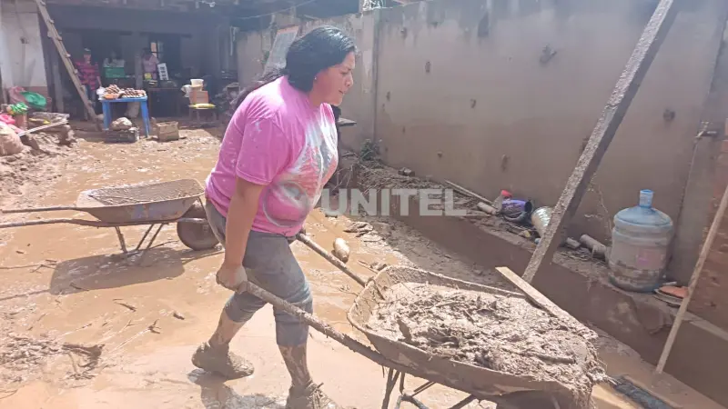 La mujer retira el lodo de su vivienda