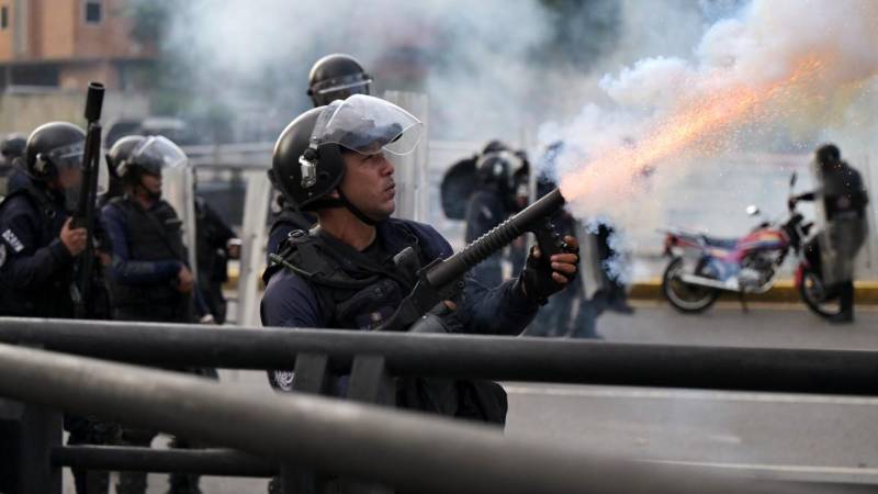 Un policía lanza gases lacrimógenos durante una protesta contra el gobierno del presidente Nicolás Maduro en Caracas.