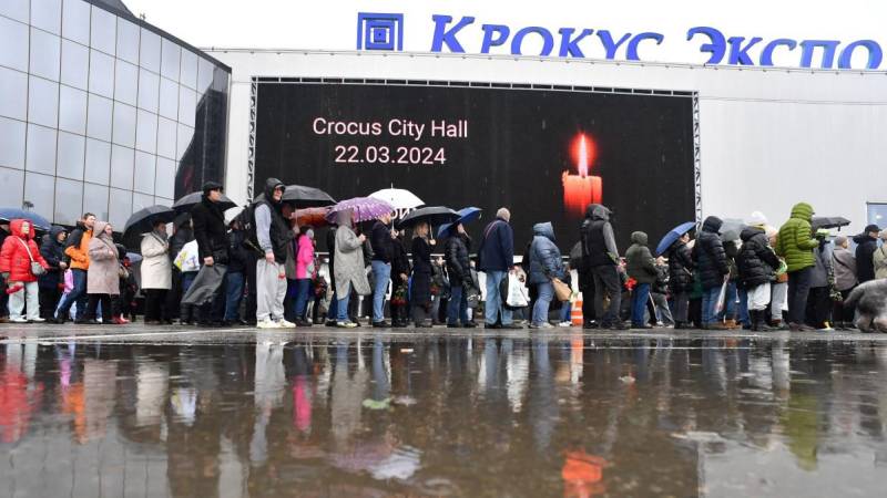 Los dolientes hacen cola para depositar flores en un monumento improvisado frente al Ayuntamiento de Crocus en Krasnogorsk.