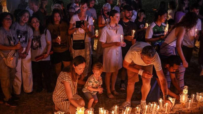 Dolientes colocan velas en el Parque Conmemorativo del Tsunami Ban Nam Khem